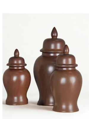 Set of three brown ceramic jars with lids on a white background