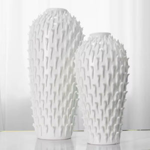 Two white textured vases on a light gray background
