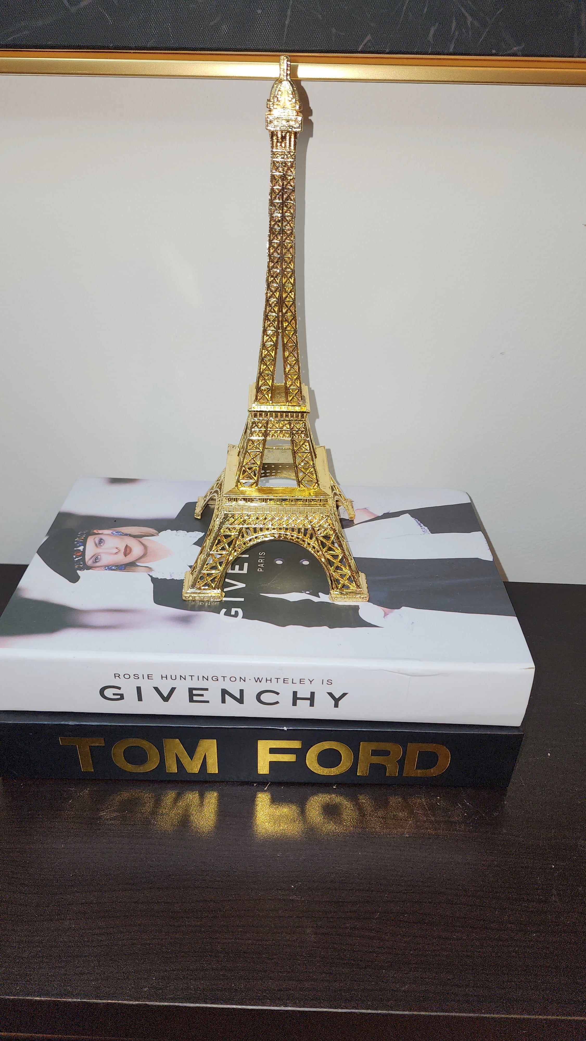 Eiffel Tower statue with golden color shown on books